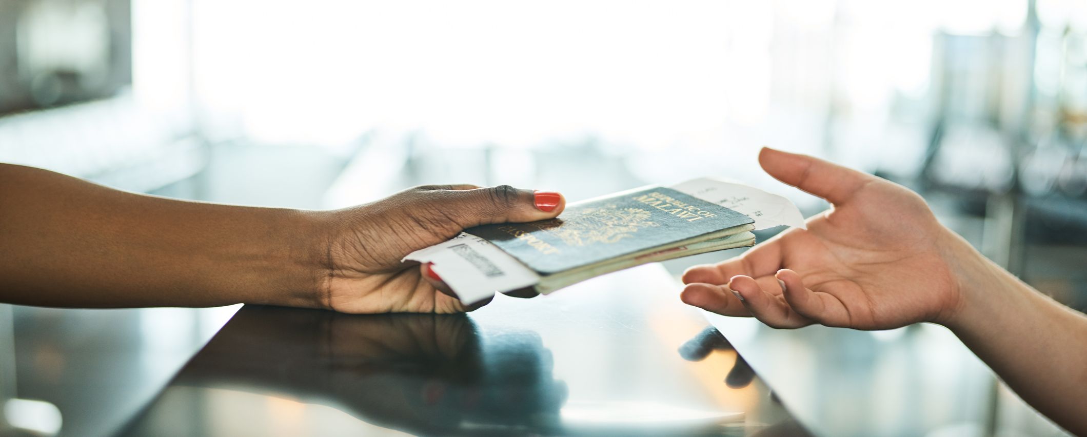 Cropped shot of an unrecognizable woman handing over her ID book at a boarding gate in an airport